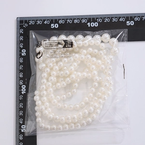 Gros plan d'une chevillère en perles blanches avec règle graduée pour référence de taille