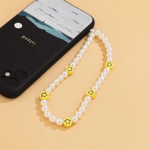 Detail of beaded phone strap with white faux pearls and yellow smiley face charms