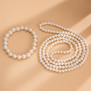 Détail d'un ensemble élégant de collier et bracelet en perles blanches au fini brillant