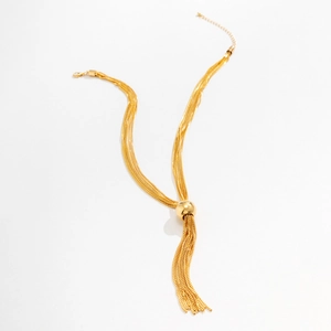 Détail de collier doré multi-rangs avec perle en métal poli et chaîne de réglage réglable
