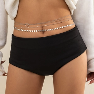 Détail de chaîne de corps argentée multicouche avec pendentif cœur et paillettes à la taille