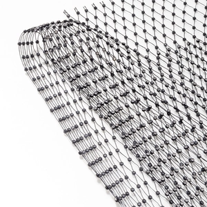 Detailaufnahme von schwarzem Netzstoff mit funkelnden Strasssteinen für Bodychain