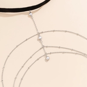Detail van zilveren dijketting met imitatieparels en gelaagd kwastjesontwerp