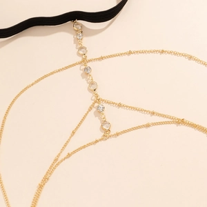 Detailopname van gouden dijketting met sprankelende strass en zwarte elastische band
