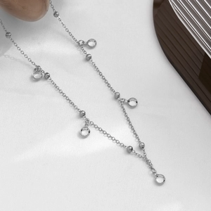Détail d'une chaîne argentée polie avec de scintillants pendentifs en cristal clair