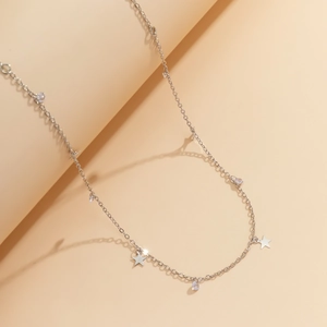 Détail d'une ceinture chaîne argentée avec étoiles métalliques et pendentifs cristal