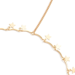Detailopname van gouden sterhangers aan een golvende metalen beenketting