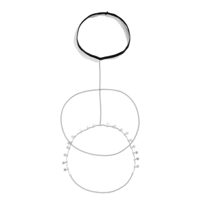 Detail van zilveren dijbeenketting met sterhangers en zwarte elastische band