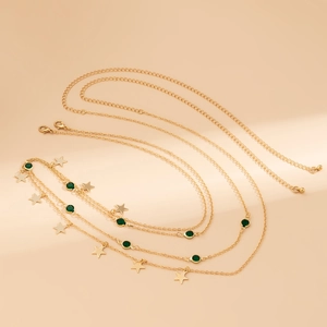 Détail de ceinture chaîne dorée multicouche avec perles vertes et charms d'étoile