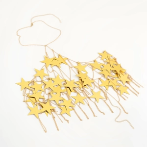 Dettaglio delle paillettes a stella dorate e della catena per il corpo in metallo moda