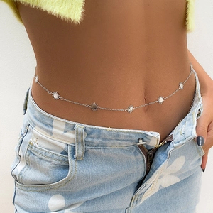 Silver chain waist belt with sunburst metal pendants worn on jeans by a model