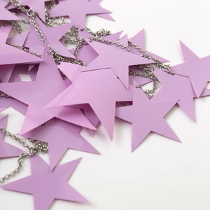 Vista dettagliata di paillettes viola a stella e catene in argento su gioielli corpo