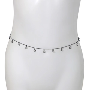 Détail d'une chaîne de taille en métal noir avec des charms en cristal sur mannequin