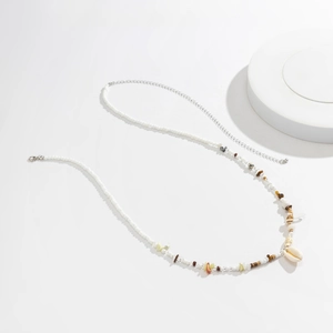 Dettaglio catena per il corpo boho con conchiglie naturali e pietre colorate