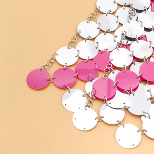 Dettaglio di paillettes geometriche creative e anelli di metallo in argento e rosa