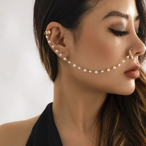 Detail of exotic gold nose ring and ear cuff with white pearl tassel chain on model