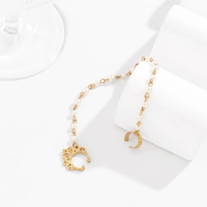 Detailed close-up of a gold-tone crown clip with elegant white pearl tassel chain