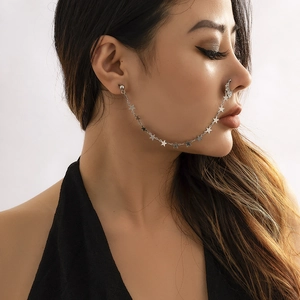 Detail of silver nose-to-ear chain with moon, star charms and faux pearl tassels