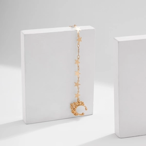 Detail of gold ear cuff with star charms on a dangling chain for women fashion