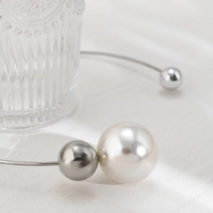 Detail of minimalist collar necklace with large pearl and polished silver metallic beads