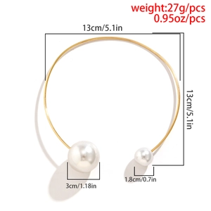 Detailed view of asymmetric gold torque choker with 3cm and 1.8cm white pearl charms