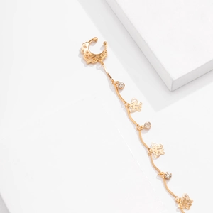 Close-up of golden butterfly fringe chain piercing jewelry with rhinestones and C-shape ring