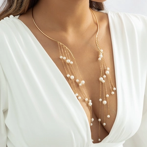 Gedetailleerde close-up van gouden choker-ketting met franjes en witte parels