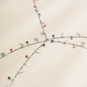 Detailed view of silver body chain featuring moon, star charms and colorful enamel beads