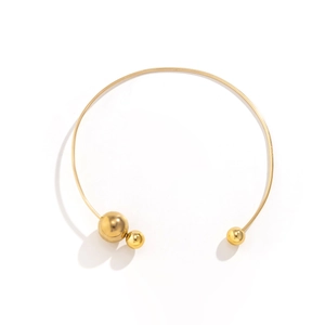 Detailed macro view of the gold collar necklace with three polished metal beads and mirror finish