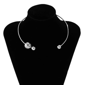 Close-up of minimalist silver metal collar featuring three asymmetrical polished spheres
