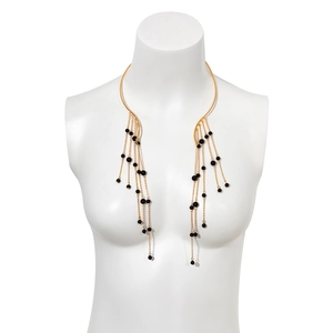 Detail van gouden kwastjes choker ketting met zwarte kralen op een open metalen frame