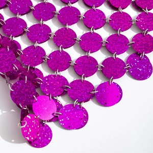 Detail van fuchsia glitterpailletten verbonden door zilveren metalen ringen in de ketting
