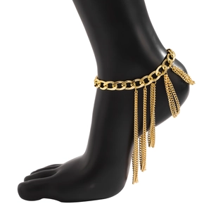 Detailed view of layered gold tassel anklet featuring a thick curb chain on model