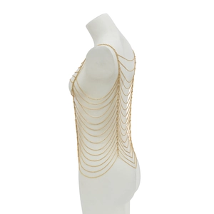 Detail of layered gold body chain showing intricate geometric metal mesh on white mannequin