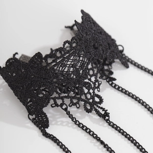 Dettaglio macro di pizzo nero gotico e frange di catene metalliche per gioielli a mano
