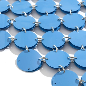 Makro-Detail von blauen runden Pailletten mit silbernen Metallringen an der Körperkette