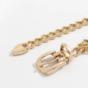Detailed close-up of a trendy gold chunky metal chain waist belt with polished oval links