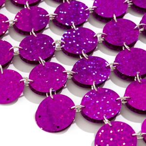 Detail der lila Pailletten Körperkette mit Silberringen und Glitzertextur Makroansicht