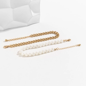 Détail de la chevillère double couche en chaîne dorée et perles avec fermoir réglable