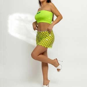 Detailansicht des neongrünen Paillettenrocks mit Metallkette und Strick-Bandeau-Top