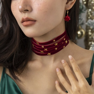 Detail of red velvet layered choker with gold stars and matching festive bow earrings