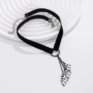 Dettaglio del choker gotico in velluto nero con tre catene e ciondoli a fantasma