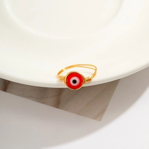 Detail of handmade gold wire-wrapped ring with a red Evil Eye bead centerpiece