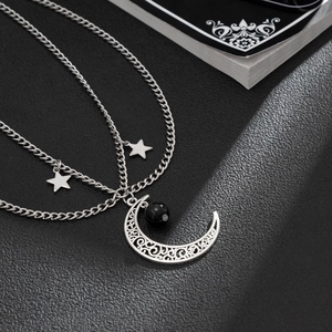 Collana a strati con luna crescente e stelle in argento su sfondo di pelle nera