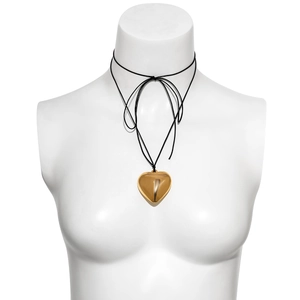 Detail view of large gold heart pendant necklace on female mannequin with black cord