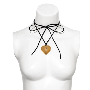 Detail of a large gold heart pendant on a black adjustable cord choker necklace