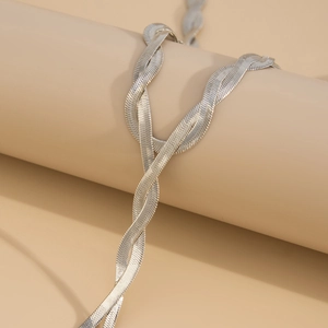 Detailed close-up of triple-strand flat snake bone chain necklace with silver metallic finish