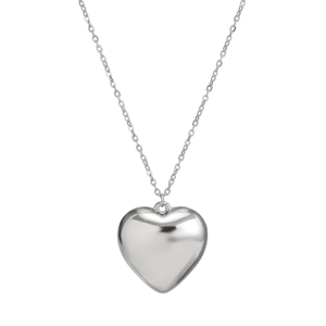 Polished silver heart pendant with velvet chain and fringe tassels macro detail
