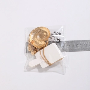 Golden starfish and shell pendant necklace measured with a ruler on white background