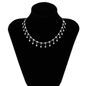 Détail du collier à pampilles argenté avec strass superposés sur un mannequin noir